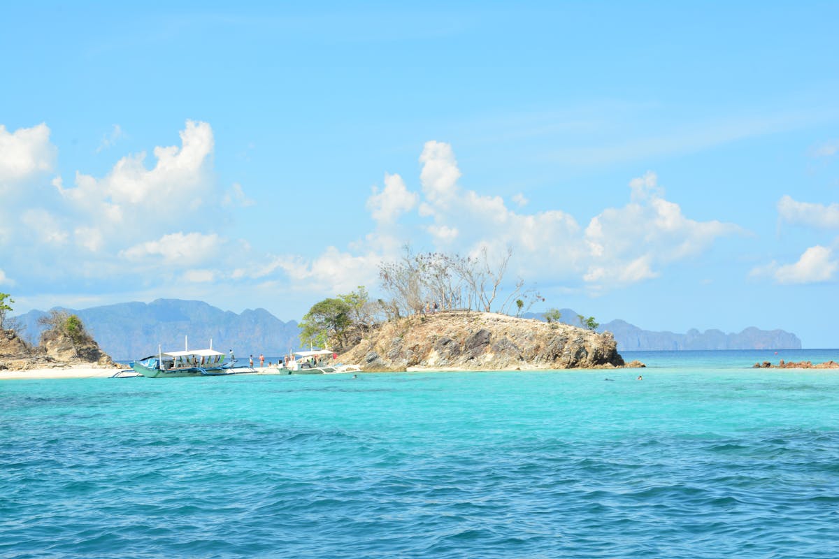 Boat on crystal-clear turquoise water during a tropical island hopping tour in the Langkawi archipelago Malaysia