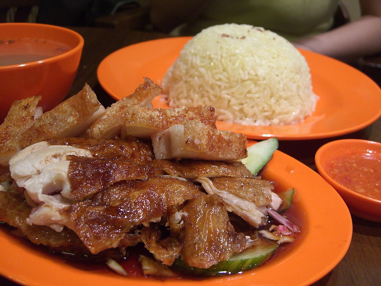 Fragrant coconut rice with pandan leaves being cooked for nasi lemak