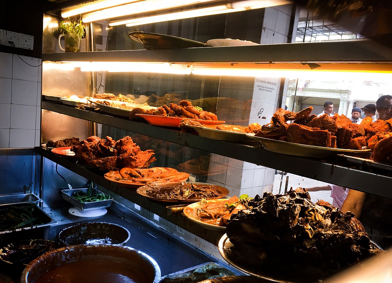 Nasi kandar rice served with multiple curry gravies at a Malaysian hawker stall