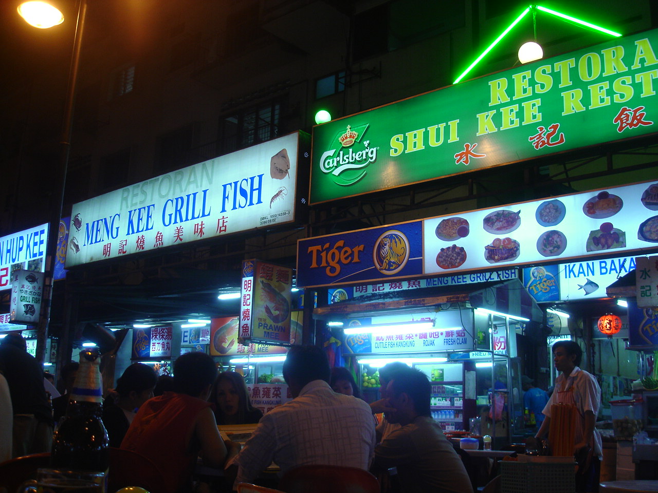 Jalan Alor food street in Kuala Lumpur lit up at night with hawker stalls and diners