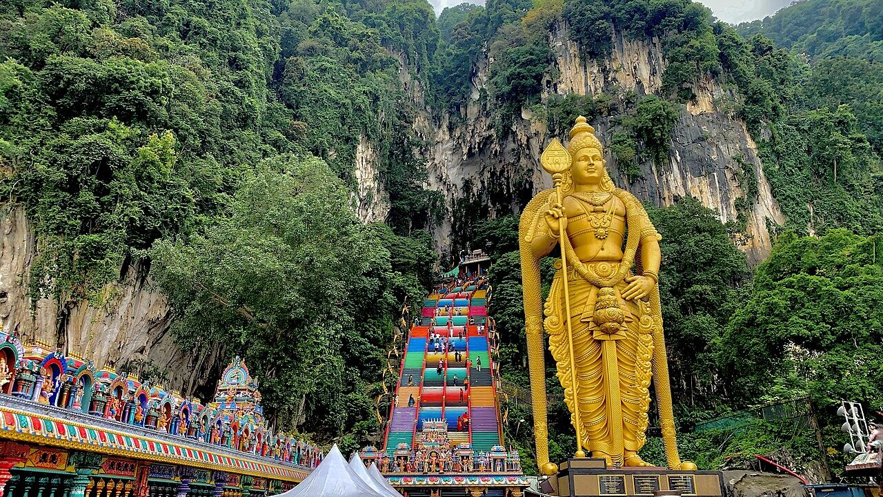 Rainbow-painted stairs and the gold Murugan statue at Batu Caves near Kuala Lumpur