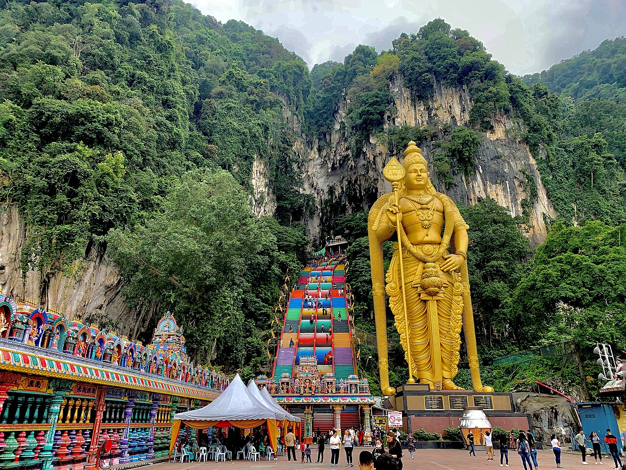 Rainbow-painted stairs and the gold Murugan statue at Batu Caves near Kuala Lumpur