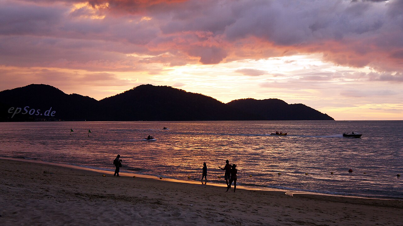 A couple watching the sunset on a Malaysian beach, a scene typical of honeymoon and romantic getaways