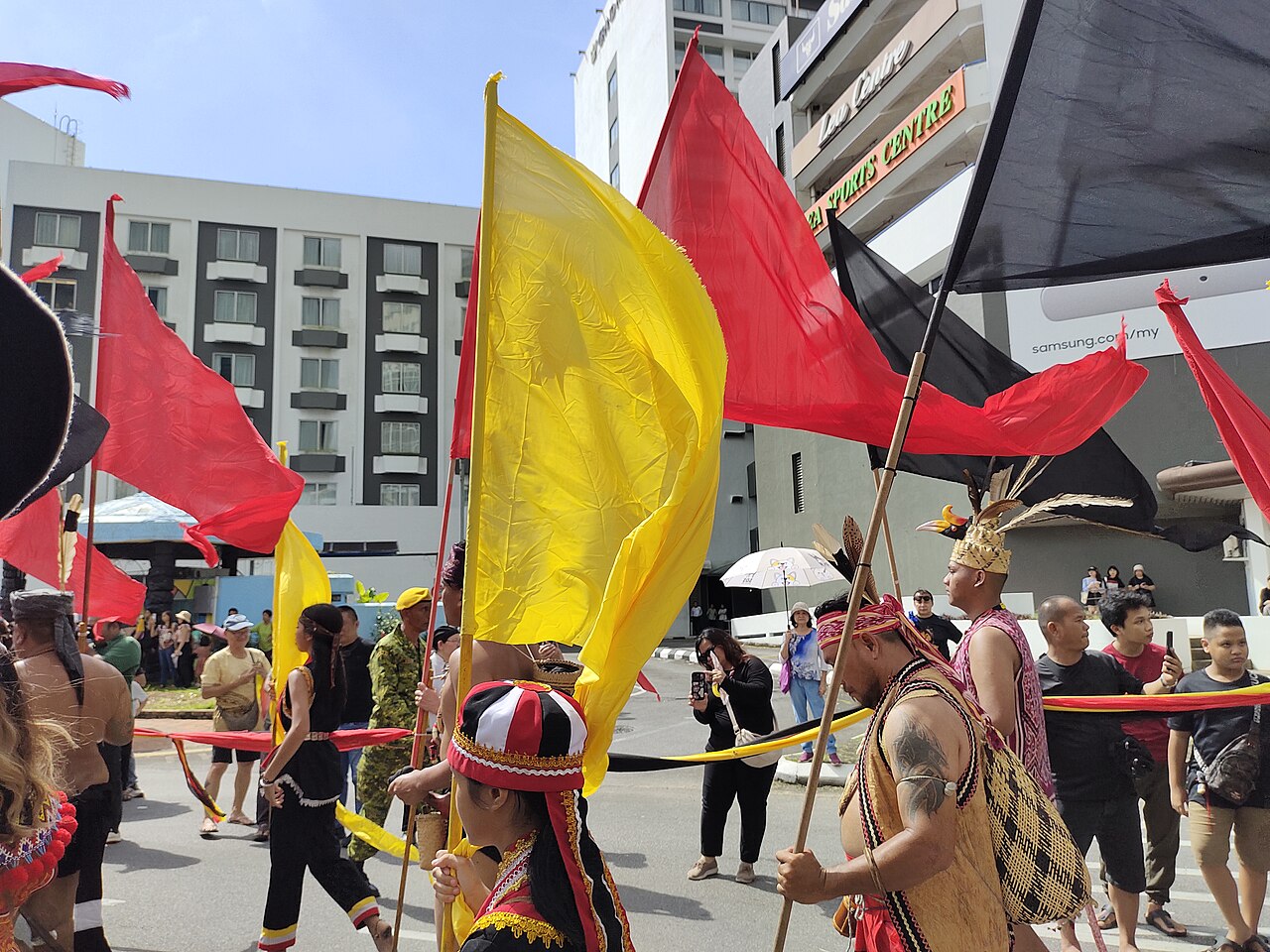 Participants carrying flags in a Gawai Dayak street procession