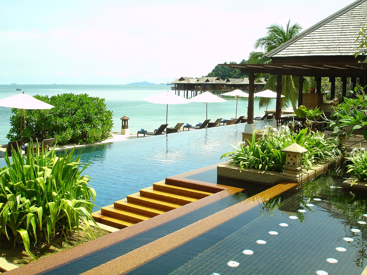 Infinity pool overlooking overwater villas at a resort on Pangkor Laut, Malaysia