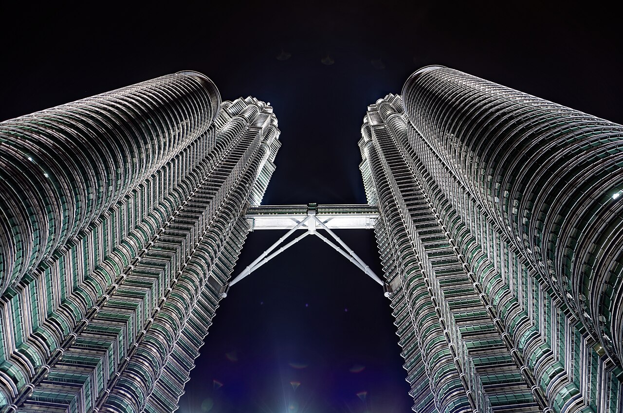 The Petronas Twin Towers and their skybridge seen from below at night