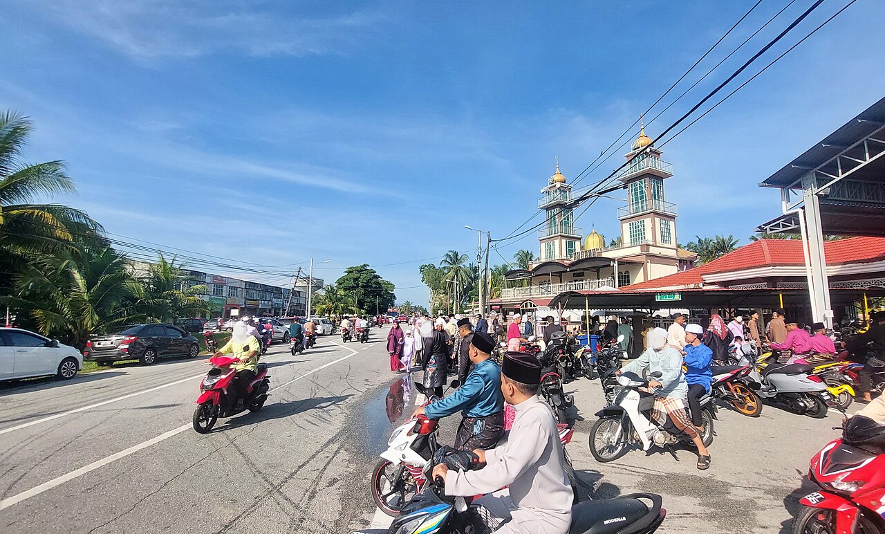 Worshippers and motorcycles outside a village mosque after Aidilfitri morning prayers