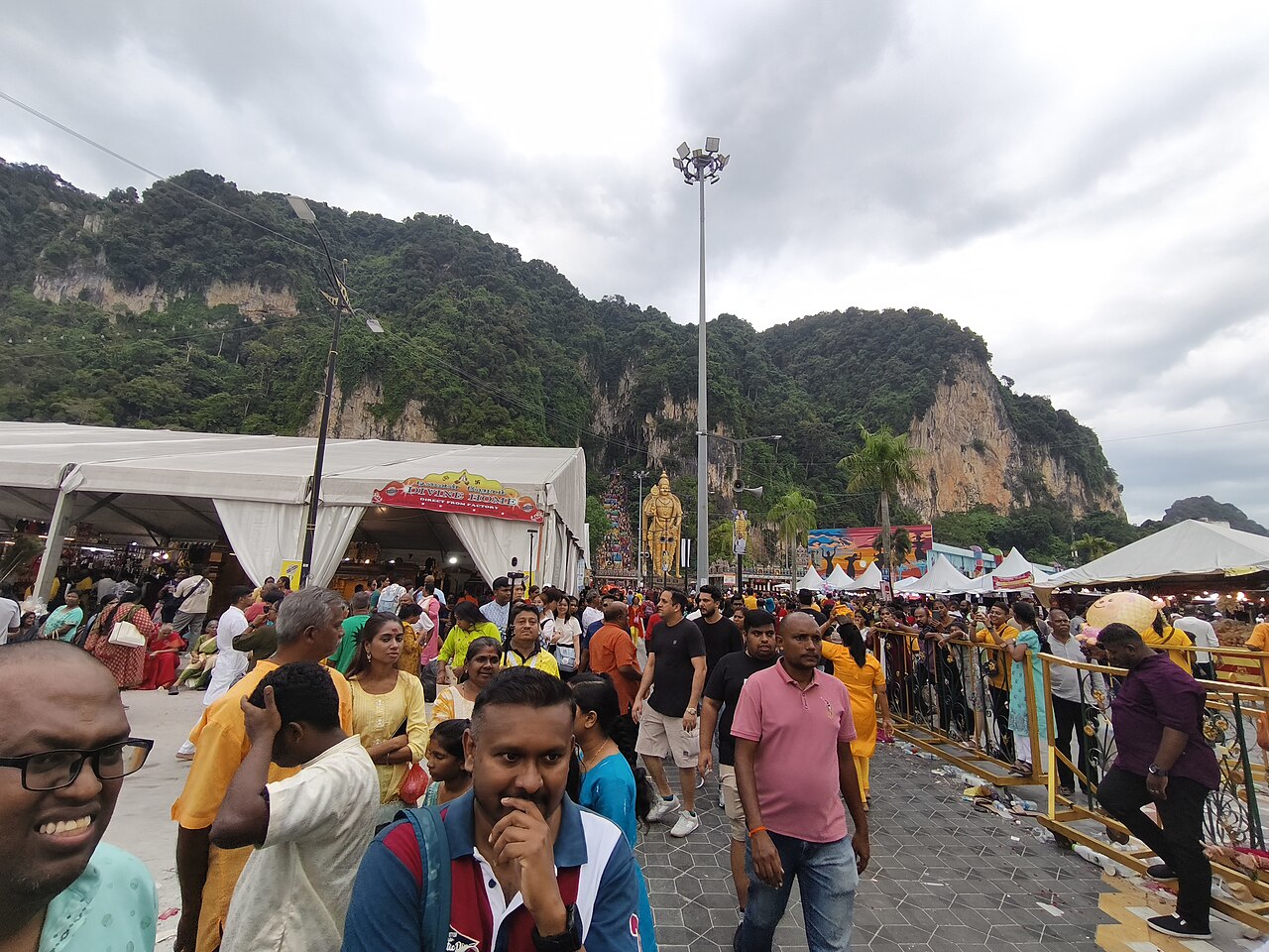Crowds filling the approach to Batu Caves beneath the limestone hills during Thaipusam
