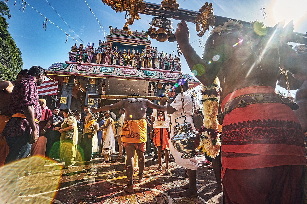 A kavadi bearer in front of a temple gopuram at Thaipusam in Ipoh