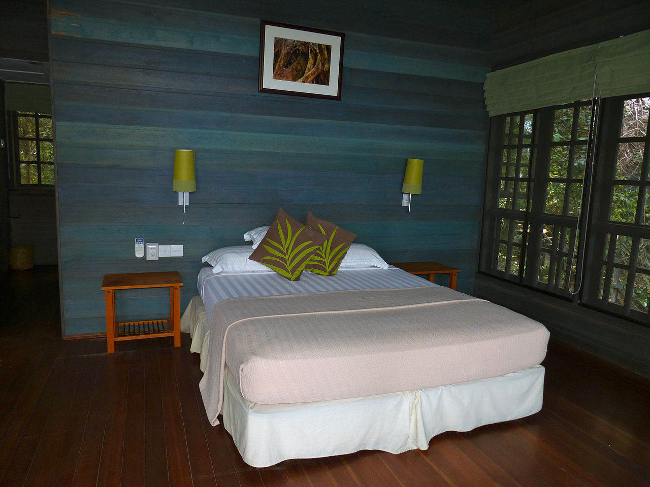 Interior of an elevated treehouse room with bed and wet bar at Permai Rainforest Resort