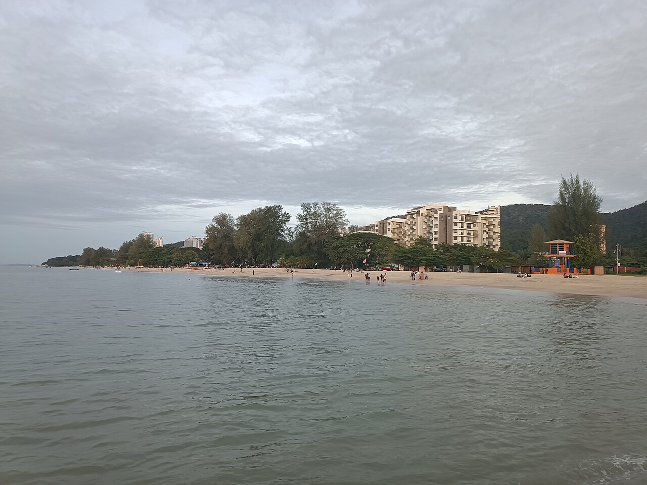 The sand and hazy water of Batu Ferringhi beach on Penang's north coast